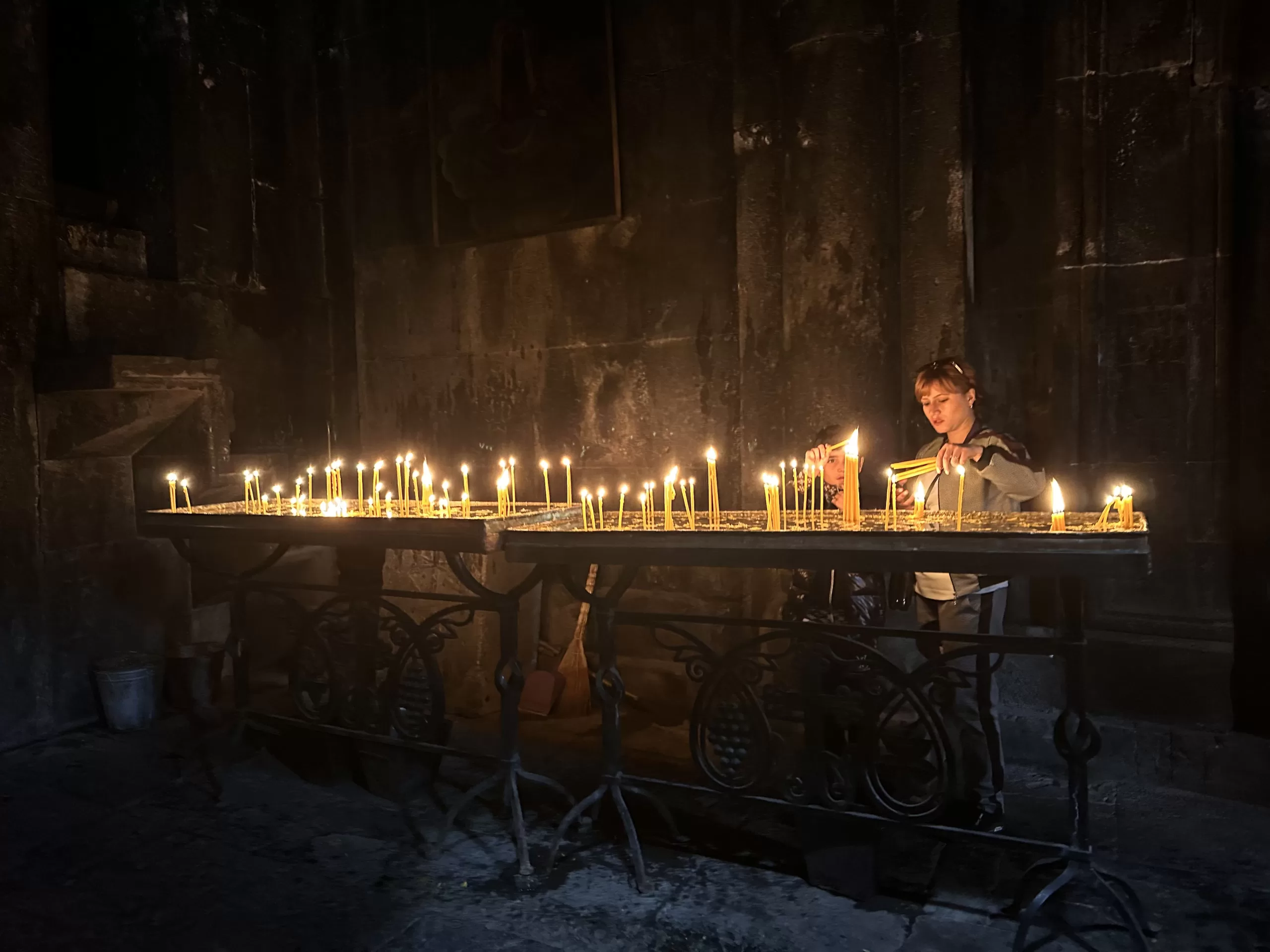 Creyentes encendiendo velas en el monasterio